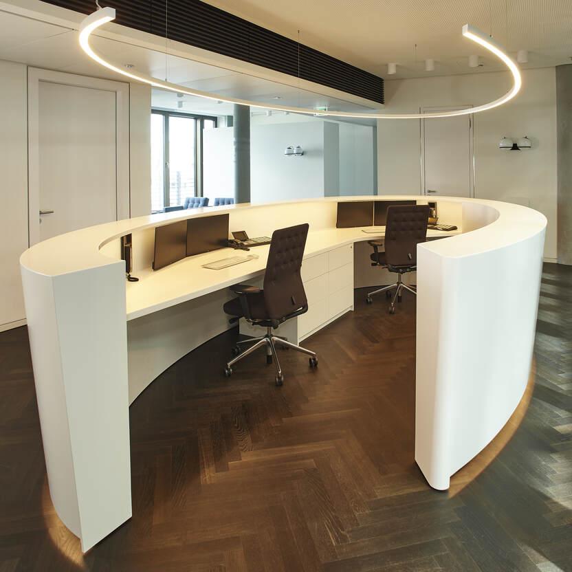 Moderner Empfangstresen in einem Bürogebäude Ein stilvoller, geschwungener Empfangstresen in einem Büro, der Eleganz und Professionalität ausstrahlt.