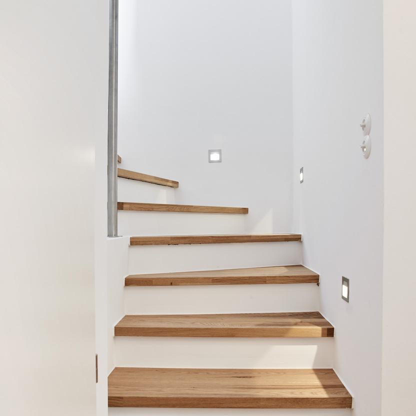 Maßgefertigte Holztreppe in einem modernen Haus Eine maßgeschneiderte Treppe mit warmen Holzstufen und integrierter Beleuchtung, die eine elegante Verbindung schafft.