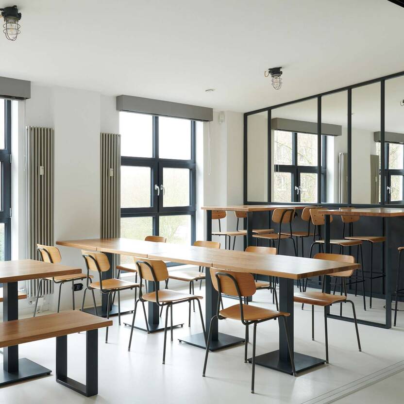 Helles, maßgefertigtes Küchendesign mit stilvollen Esstischen und Stühlen, umrahmt von großen Fenstern.