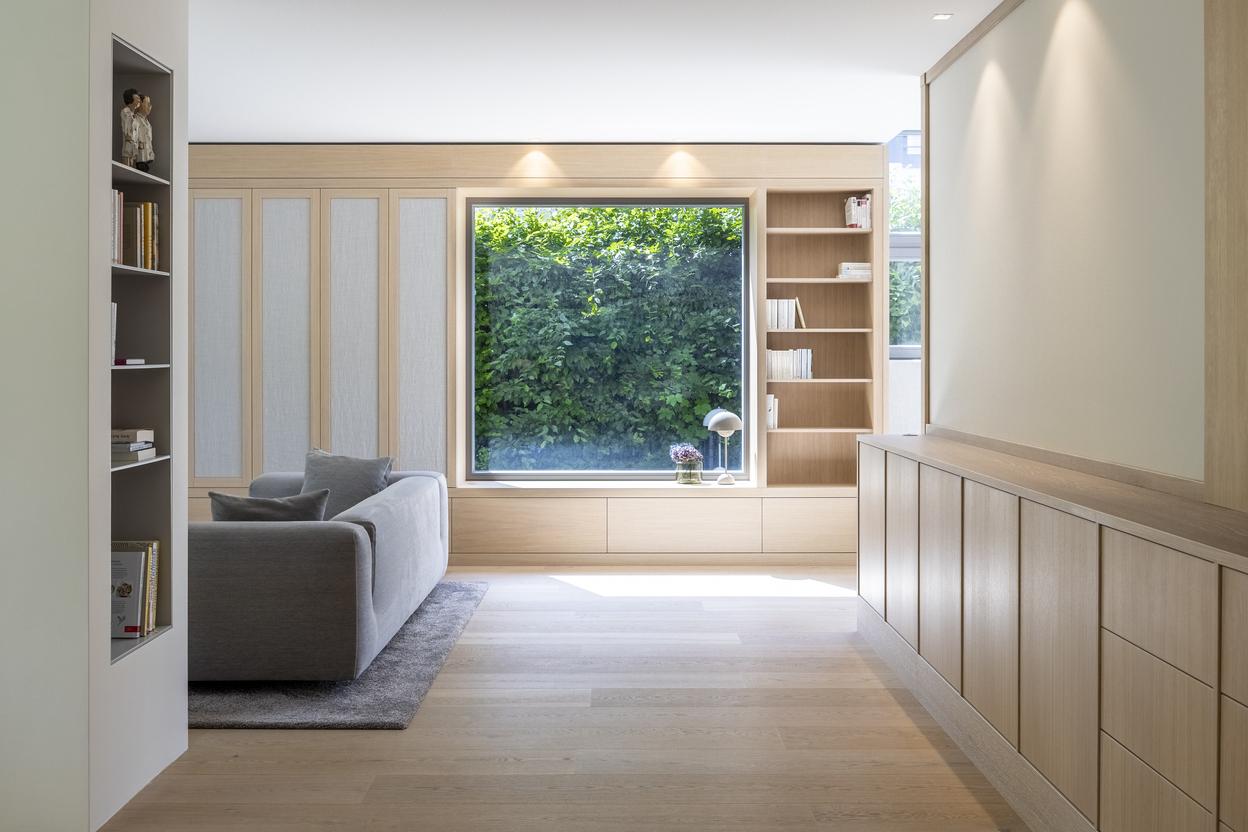 Ma&szlig;gefertigte Einbaum&ouml;bel aus hellem Holz mit Schrankfronten, B&uuml;cherregalen, Schubladen und gro&szlig;er Fensternische.