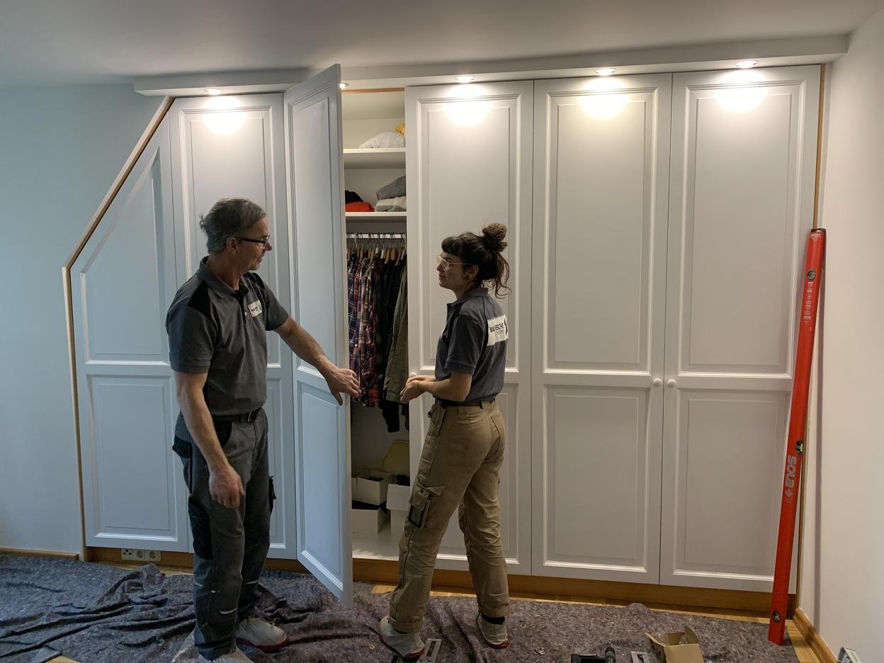 Maßgefertigter Schrank aus weißem Holz mit Schräge und Beleuchtung Tischlerei Max Fesche