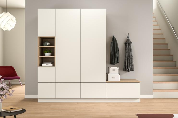 Helle, maßgeschneiderte Schrankeinheit im Flur mit offenem Fach, Schubladen und integrierter Garderobe, harmonisch kombiniert mit warmen Holztönen.